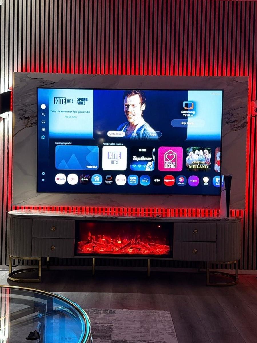 Cinewall met zwarte lamellenwand, rode ledverlichting en een tv-meubel met sfeerhaard