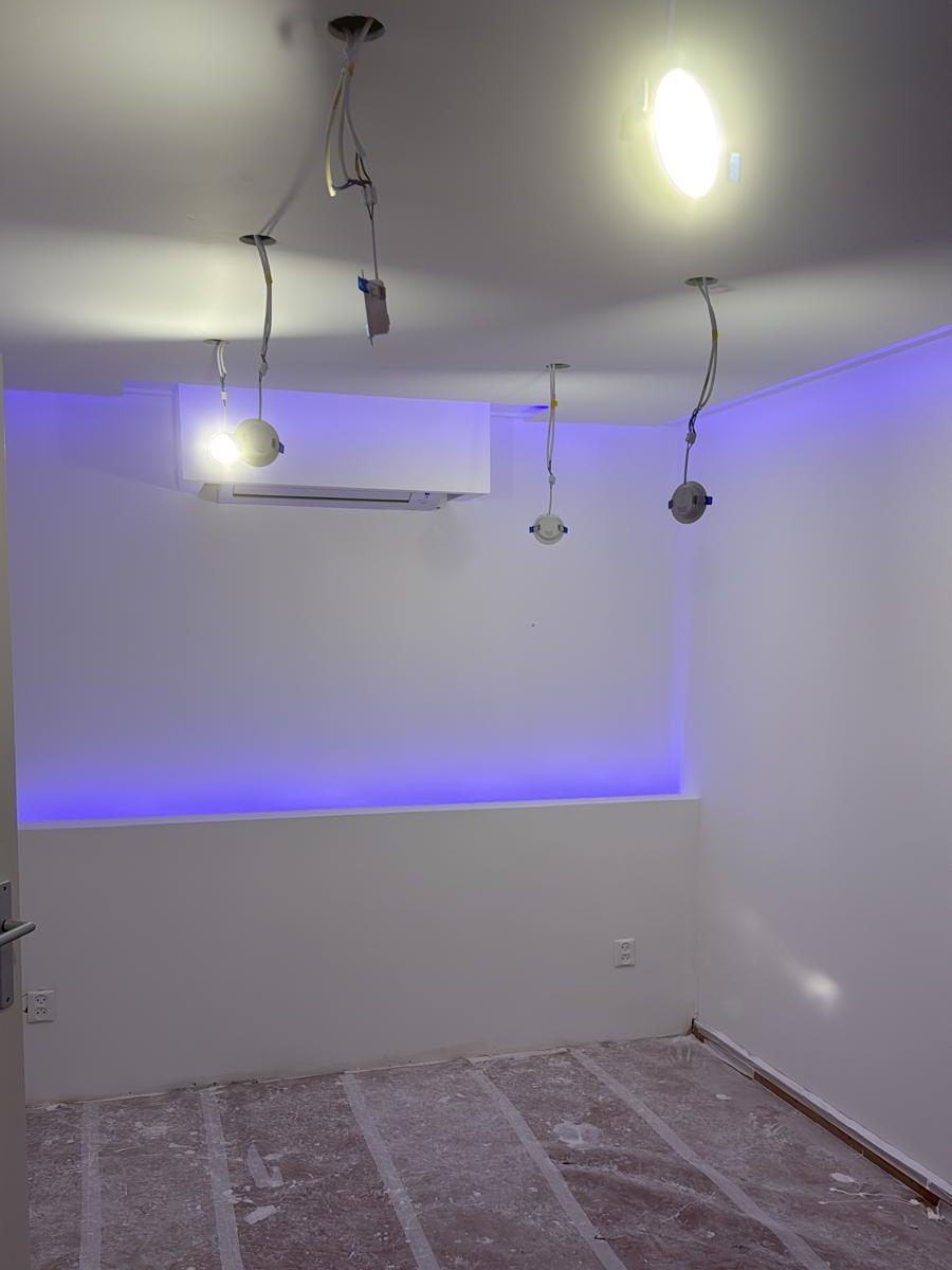 Kamer met verlaagd plafond, inbouwspots en een ledstrip langs de wand