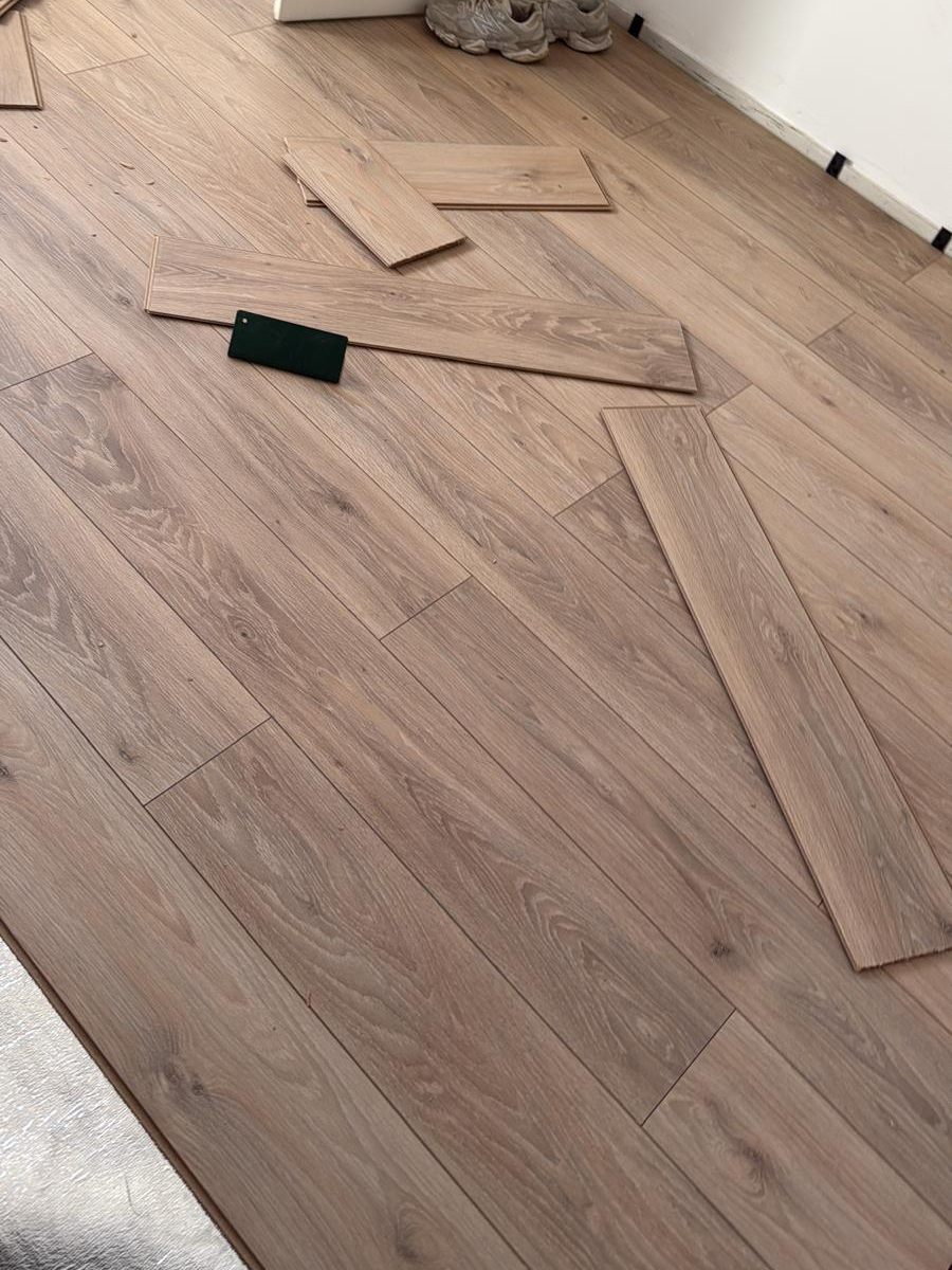 Nieuw gelegde laminaatvloer met losse planken klaar om verder te leggen