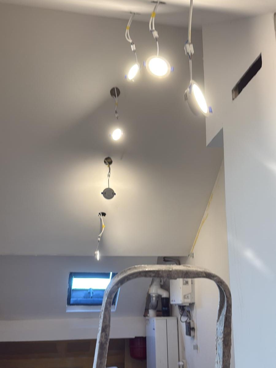 Afgewerkte zolder met gladde witte wanden en inbouwspots