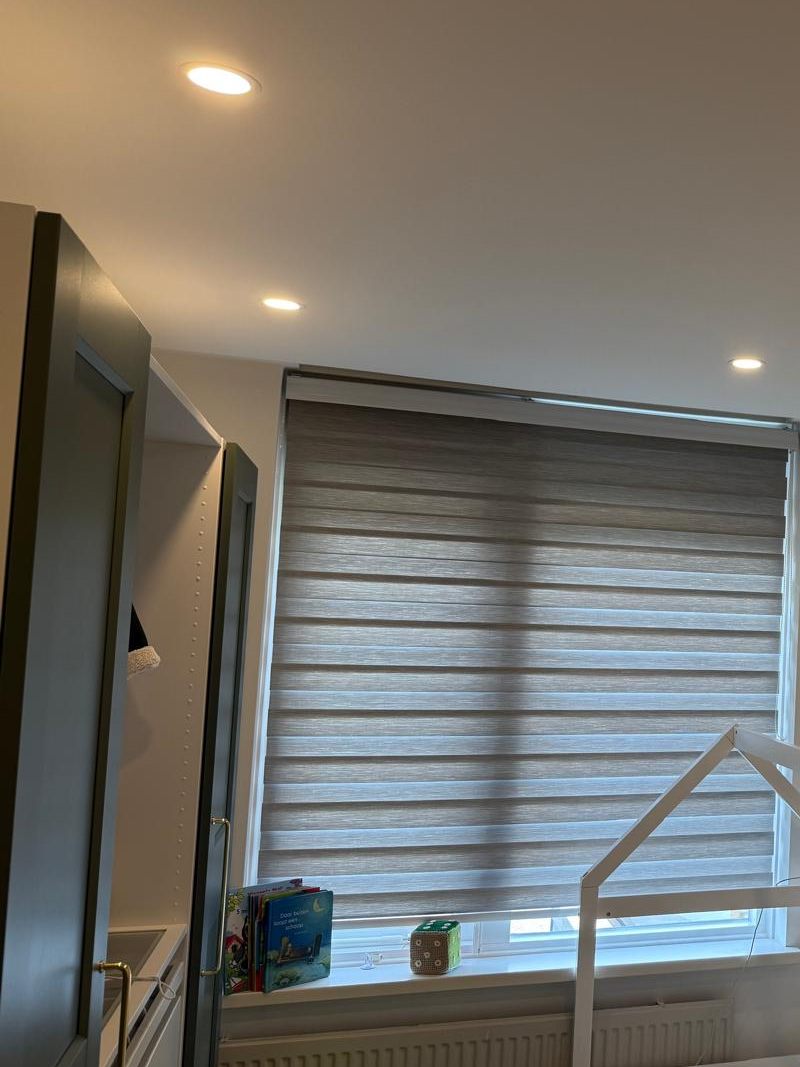 Opgeleverde slaapkamer met strak plafond, inbouwspots en een gordijnrail