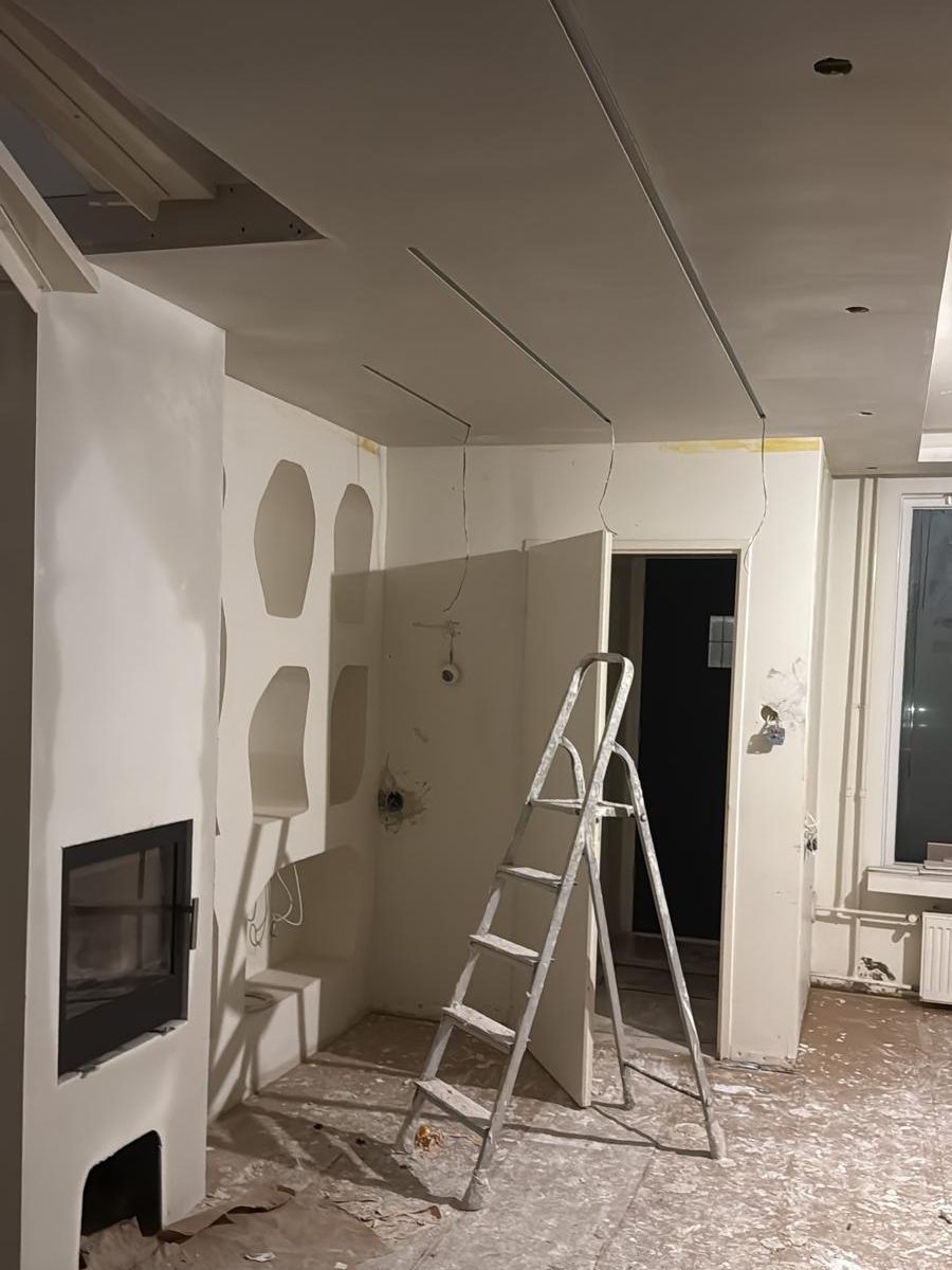 Nissenwand in aanbouw met gipswerk, weggewerkte leidingen en een verlaagd plafond