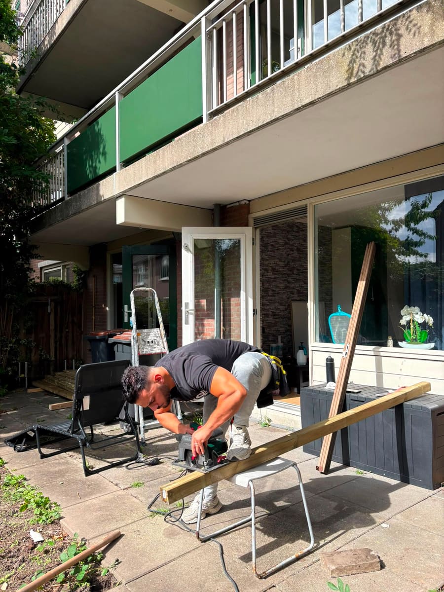 Timmerman zaagt met een cirkelzaag de laatste balk voor de berging op maat